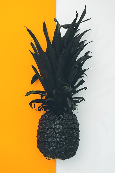 Черный ананас на бело-желтом фоне